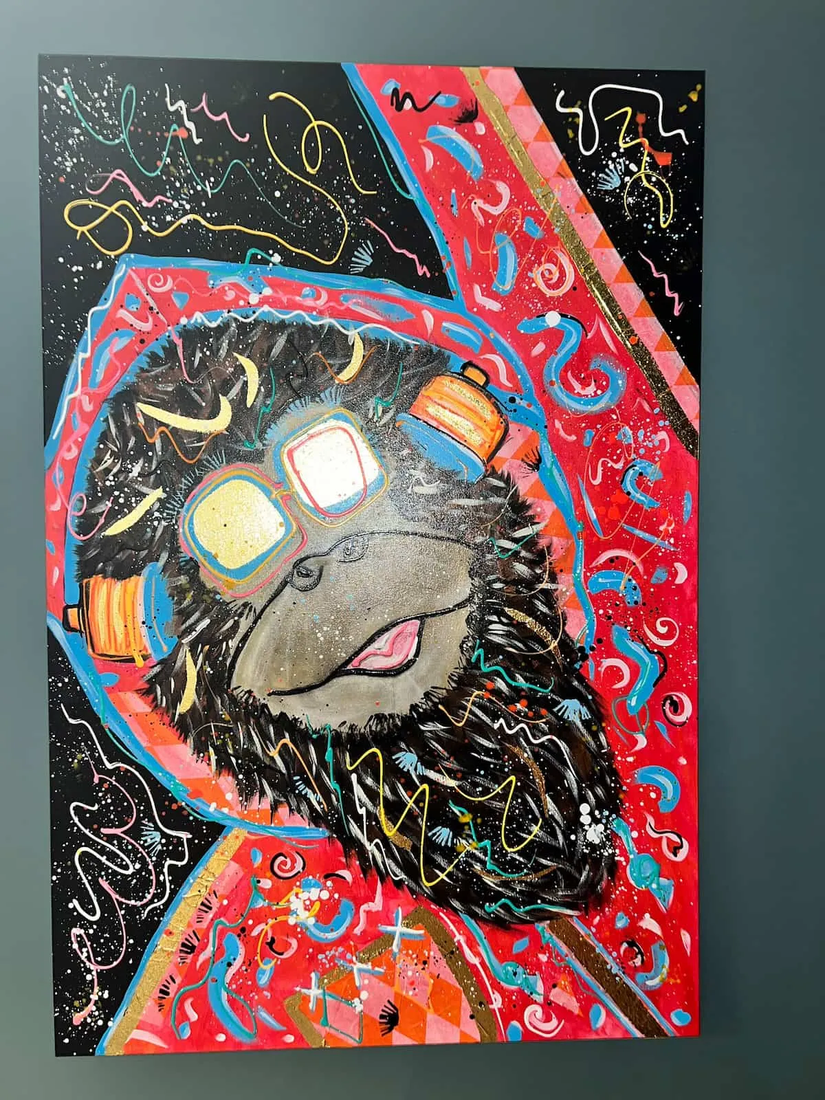 Gorilla in goggles and a red hood on a black canvas