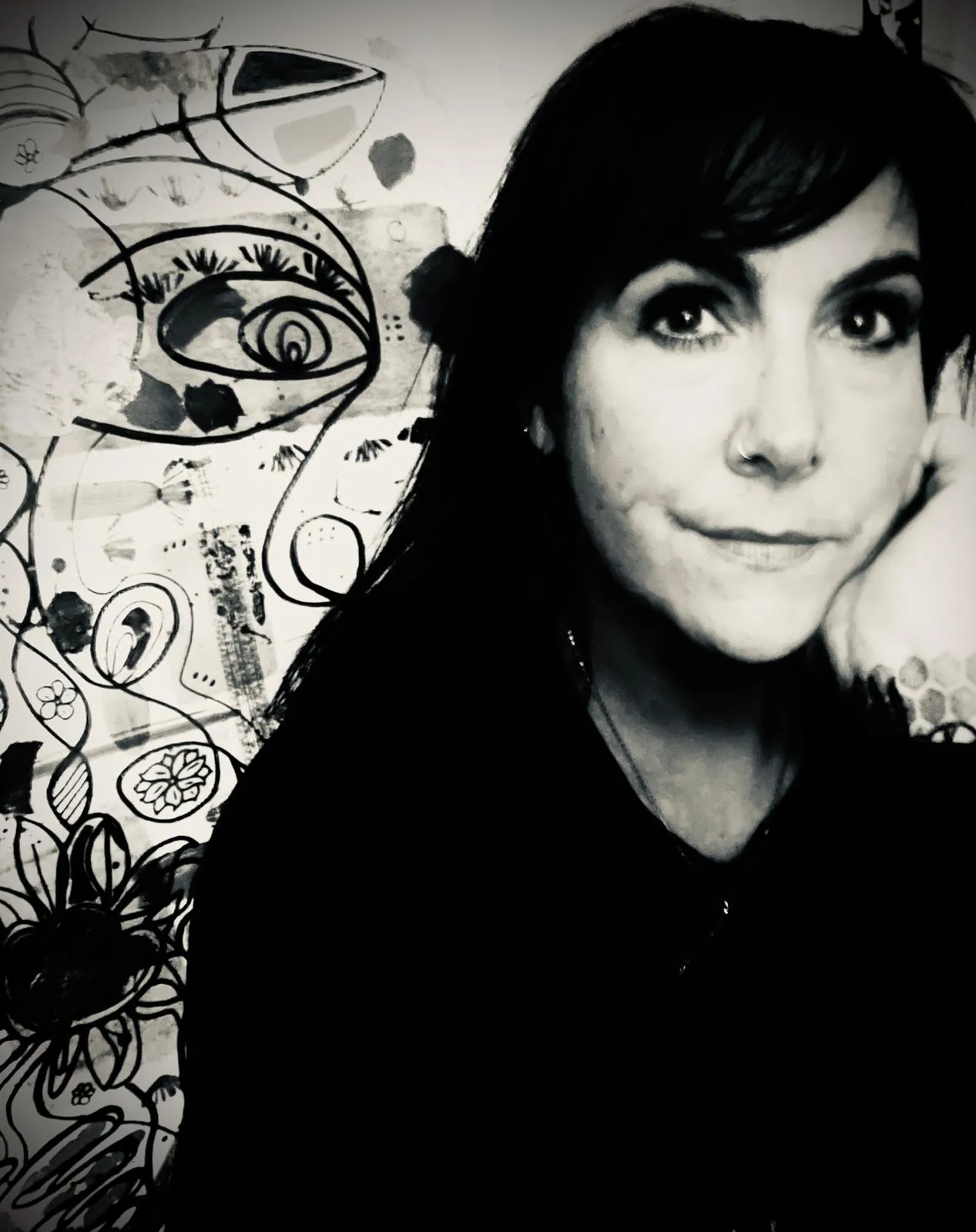 Black and white portrait of Joules Rain in front of her ink artwork